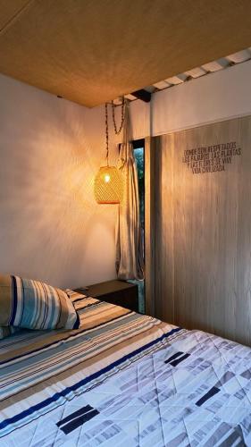 a bedroom with a bed with a light on the wall at House Viotá in Viotá