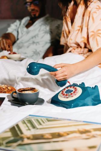 a woman is pouring coffee into a cup on a bed at Hotel Indigo Sydney Potts Point by IHG in Sydney