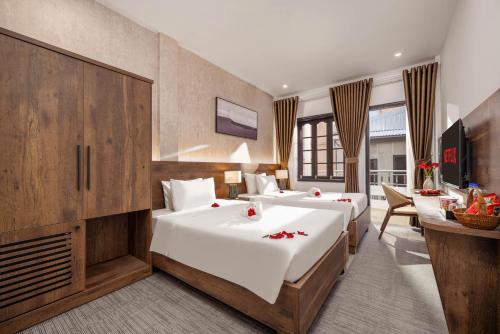 ein Hotelzimmer mit zwei Betten und einem Schreibtisch in der Unterkunft Kly Luxury Hotel in Hue