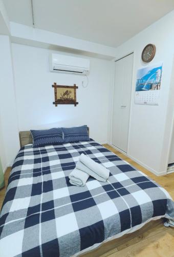 a bedroom with a blue and white checkered bed at #201WZNET梅屋敷駅2分横浜羽田空港都心便利商店街1k静かな町 in Tokyo