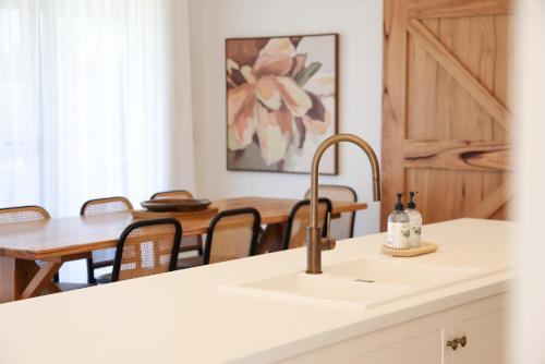 una cucina con lavandino e tavolo da pranzo di Kookaburra Beachhouse - Coastal Farmhouse Retreat a Robe