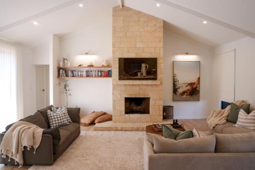 un soggiorno con due divani e un camino di Kookaburra Beachhouse - Coastal Farmhouse Retreat a Robe