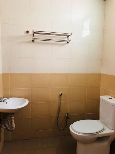 a bathroom with a toilet and a sink at Penarak Bamboo Beach Motel in Kuah