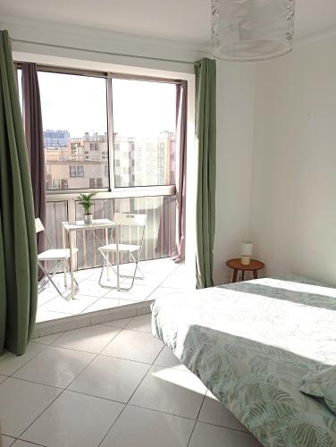une chambre avec un lit et une grande fenêtre dans l'établissement Spacieux appartement residence securisee, garage, à Marseille