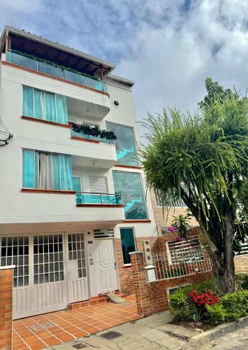 a white building with a tree in front of it at Apartamento en Bucaramanga in Bucaramanga