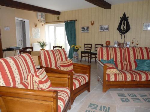 a living room with two couches and a table at Ferme de La poterie in Donnery