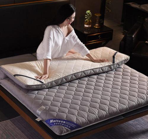 a woman sitting on top of a mattress at yourcity 台北101 和 大巨dome旁邊 大空間睡8人 in Taipei