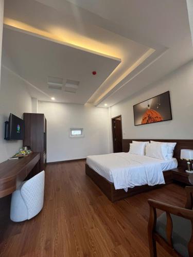 a hotel room with a bed and a desk at Hotel ĐÁ ĐỎ in Da Nang