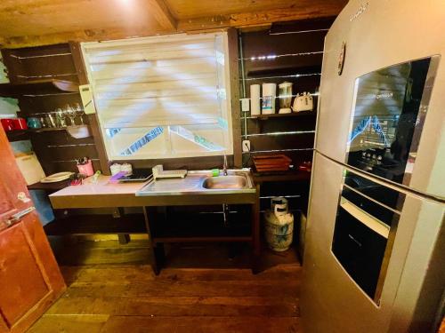 eine kleine Küche mit Spüle und Kühlschrank in der Unterkunft Departamento frente a Playa Cocles in Talamanca