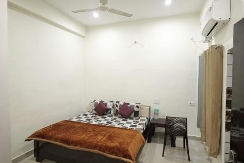 a bedroom with a bed and a table and a ceiling at Hotel Jaanvi in Orchha