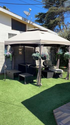 a pavilion with a table and chairs in a yard at Sofi Intuit Forum Vacation Oasis in Los Angeles
