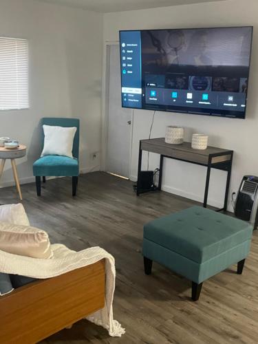 a living room with a tv and a table and chairs at Sofi Intuit Forum Vacation Oasis in Los Angeles