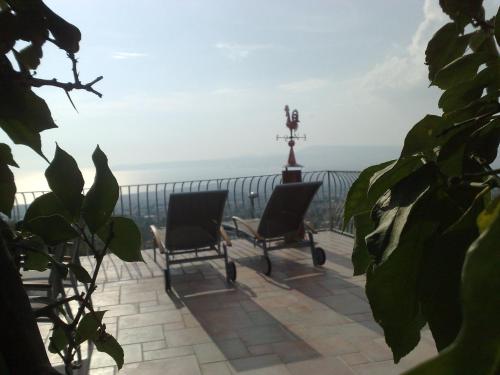 a pair of chairs on a patio with the ocean in the background at La Dimora le Fumarole Rooms in Ercolano