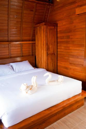 a bed in a wooden room with towels on it at Kabinku Bali in Bedugul