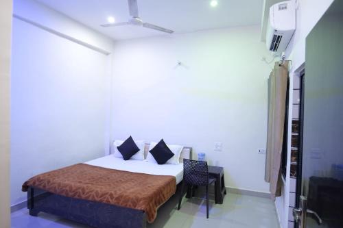 a bedroom with a bed and a chair in it at Hotel Jaanvi in Orchha