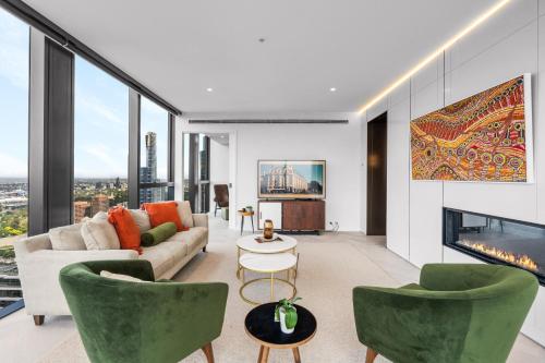 a living room with a couch and chairs and a fireplace at Collins House Apartments by CLLIX in Melbourne