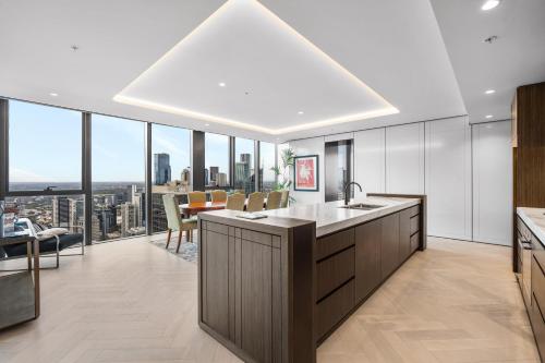 an open kitchen with a view of a city at Collins House Apartments by CLLIX in Melbourne