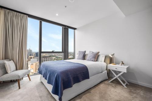a bedroom with a bed and a large window at Collins House Apartments by CLLIX in Melbourne