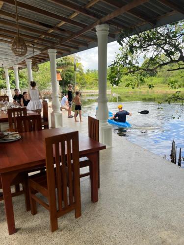 a group of people watching a man kayaking in the water at Seth Villa by Magampura Resorts in Tangalle