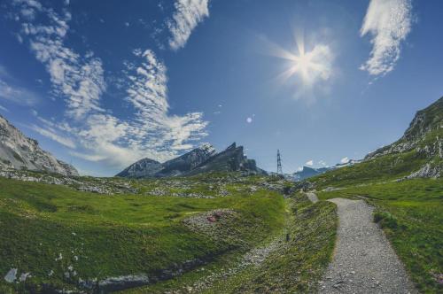 a road in the mountains under a blue sky at Apartments Residenz Iris in Leukerbad