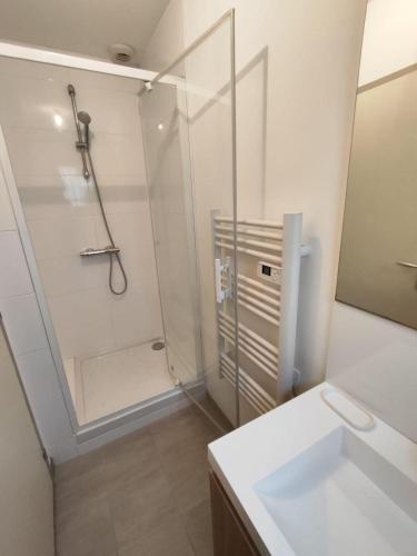 une salle de bain blanche avec une douche et un lavabo dans l'établissement 2 bedroom house, à Talence