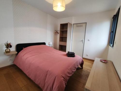 une chambre avec un lit avec une couverture rouge dans l'établissement 2 bedroom house, à Talence