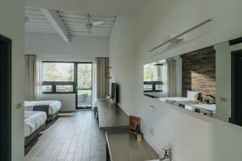 a white room with two beds and a mirror at Yanyu Yuchi BY REINDEER in Yuchi