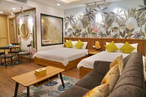 a hotel room with two beds and a couch at FLC SEATOWER Quy Nhơn in Quy Nhon