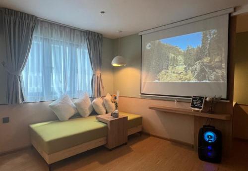 a room with a large screen with a bed and a table at Swiss Hotel Heritage Boutique Melaka in Melaka
