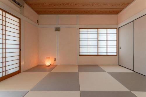 an empty room with a lamp in a room with windows at Viva Sumoto in Amakusa
