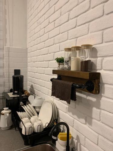 a kitchen counter with a sink with dishes on a wall at RumaTisa in Teluk Intan