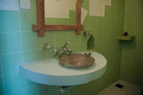 a bathroom with a sink with a mirror at Sapana Village Lodge in Sauraha