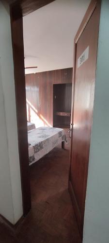 an open door to a bedroom with a bed at Hospedaria Central in Lavras