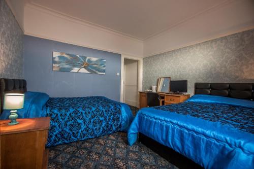 a hotel room with a bed and a desk at The Carlton Hotel in Folkestone
