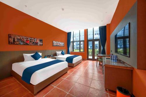 a hotel room with two beds and a desk and windows at Xikang Wellness & Resort Qingcheng Mountain in Taiping