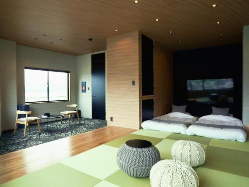 Minamiise1 and Only Hotel Io - イオ的一间卧室，配有一张床、一张桌子和几把椅子