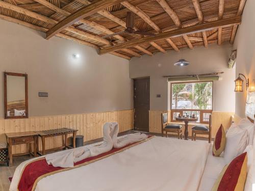 a bedroom with a large bed and a table at Echor Mud Huts Tabo, Spiti Valley in Kaza