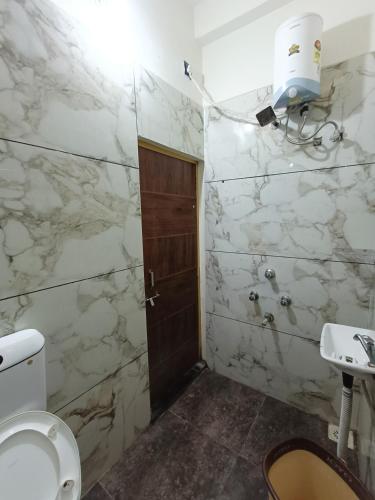 a bathroom with a toilet and a sink at Hotel Shreem in Ujjain