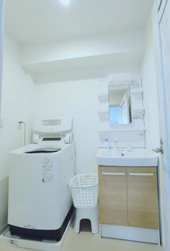 a small white kitchen with a sink and a refrigerator at #203WZNET梅屋敷駅2分横浜羽田空港都心便利商店街1ldk広い in Tokyo