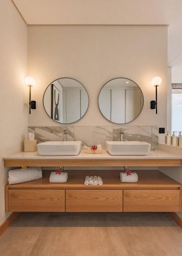 a bathroom with two sinks and two mirrors at Legend Hill Resort and Spa in Rivière Noire