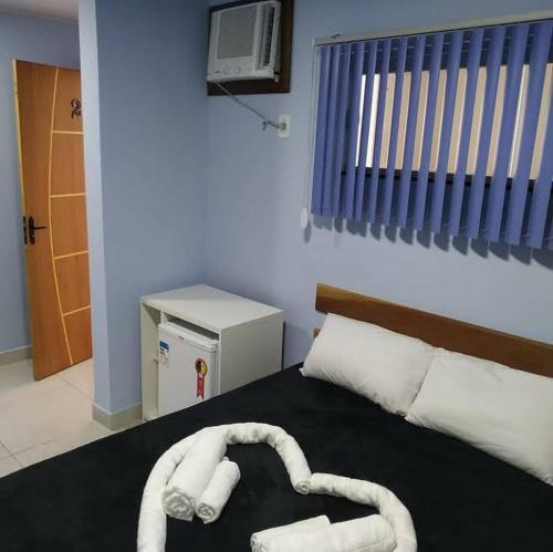 a bedroom with a bed with two towels on it at Suítes da lagoa monte alto in Arraial do Cabo