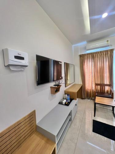 a living room with a flat screen tv on a wall at Hotel Sunlight in Puducherry