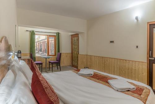 a bedroom with a large bed with two towels on it at Echor Mud Huts Tabo, Spiti Valley in Kaza