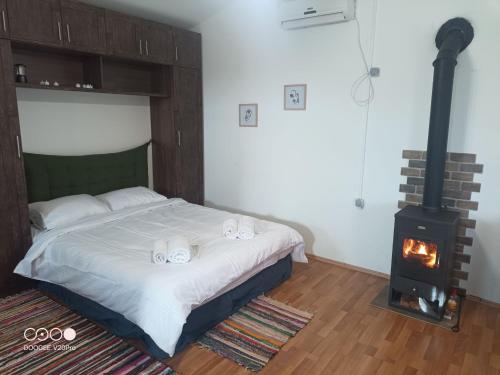 a bedroom with a bed and a wood stove at Bazaleti Field House in Karsimaantkari