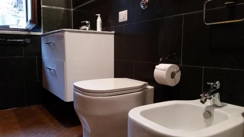 a bathroom with a white toilet and a sink at Traditional sicilian home in Mistretta