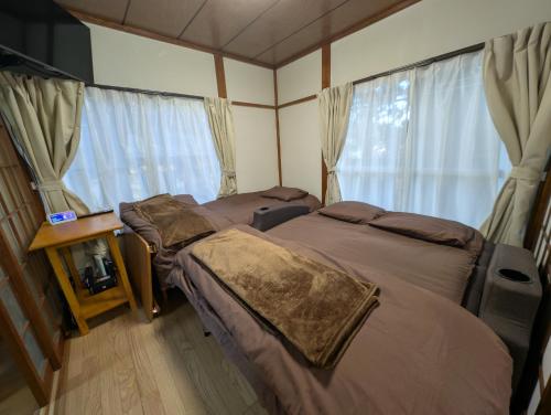 two beds in a room with a window at Safa's Guest House in Nikko