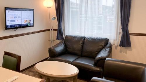 a leather couch in a waiting room with a window at Toyoko Inn Hiroshima Ekimae Ohashi Minami in Hiroshima