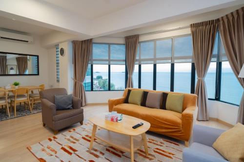 a living room with a couch and a table at Twynstar Mutiara Melaka Beach Resort in Tangga Batu