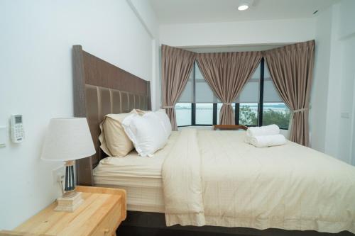 a bedroom with a large bed with a large window at Twynstar Mutiara Melaka Beach Resort in Tangga Batu