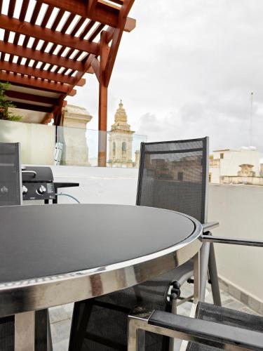 a table and chairs sitting on top of a roof at Fly Away Home condo with terrace in Qormi